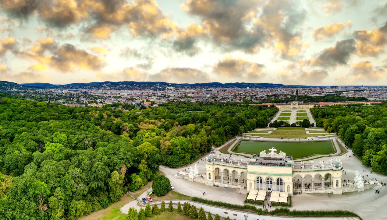 Panoramaaufnahme von Schloss Schönbrunn und den Gärten bei Sonnenuntergang – ein Highlight des kulturellen Luxus in Wien, ergänzt durch diskrete Services wie Escort Service Wien.