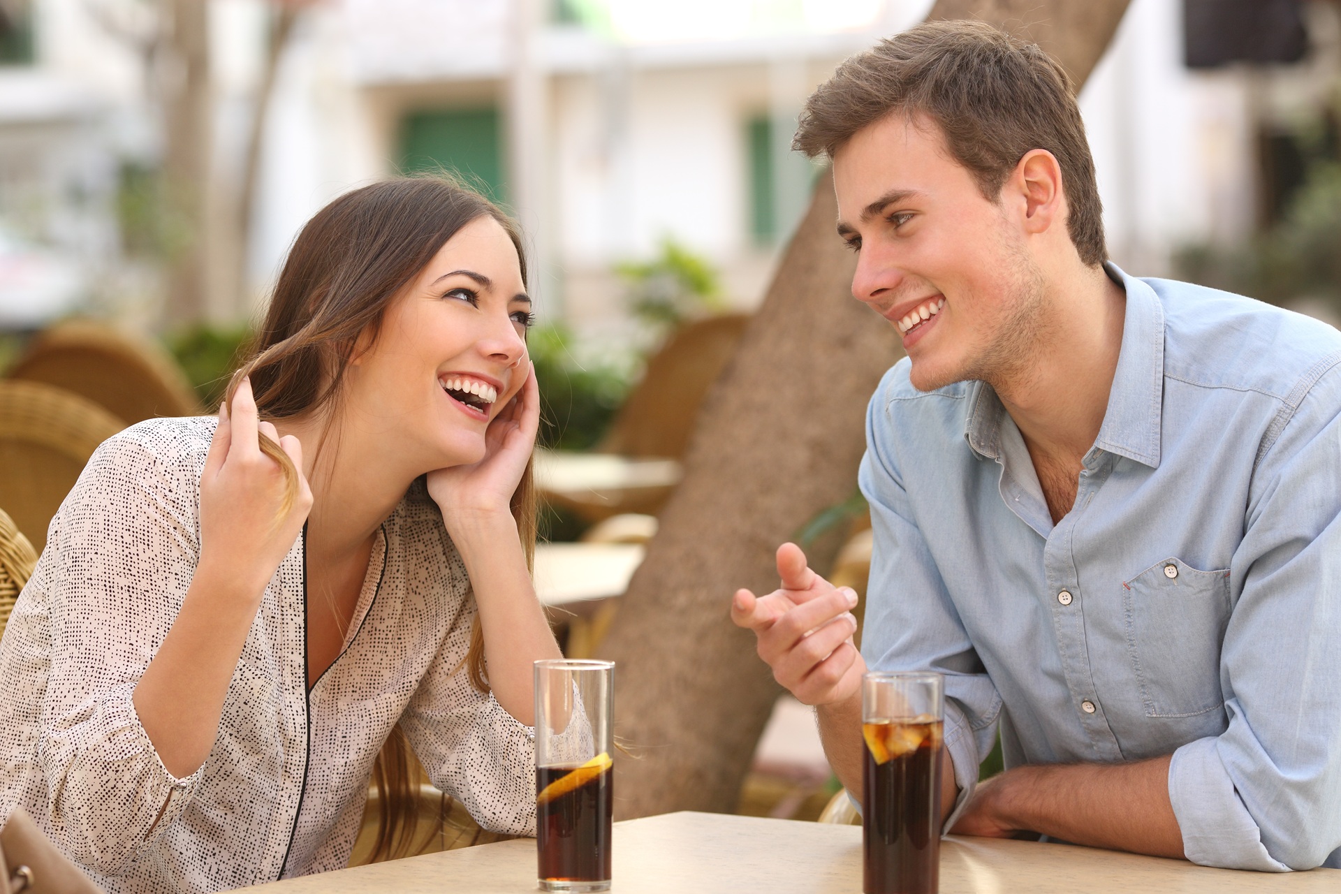 Paar lacht und flirtet bei Gespräch im Cafe | High Class Escort